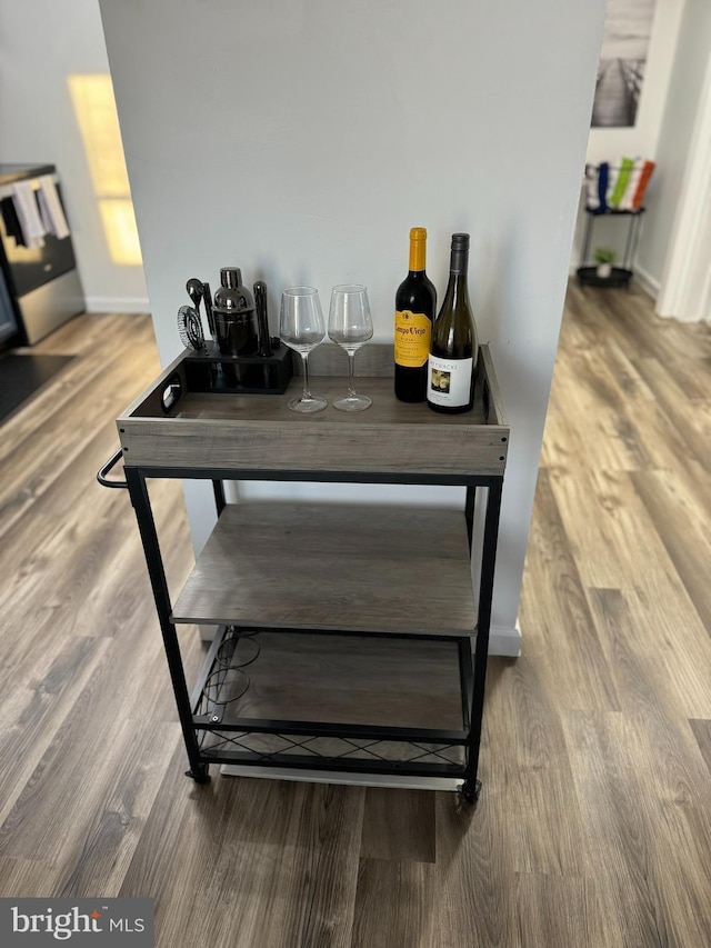 dining area with hardwood / wood-style flooring and indoor bar