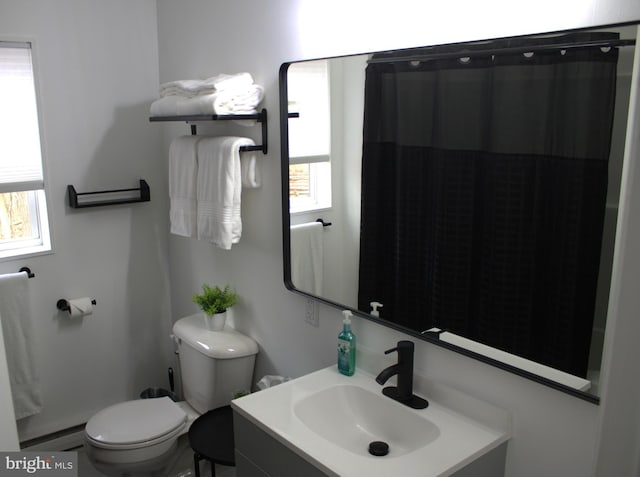 bathroom with toilet, baseboard heating, a wealth of natural light, and vanity