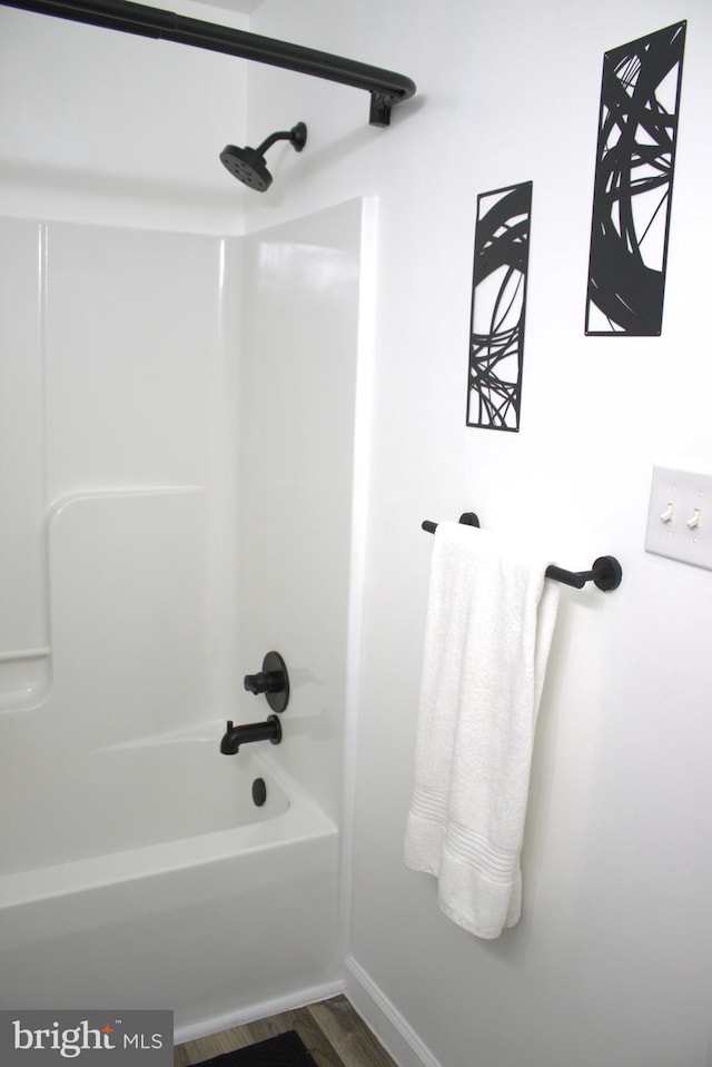 bathroom featuring washtub / shower combination and hardwood / wood-style floors