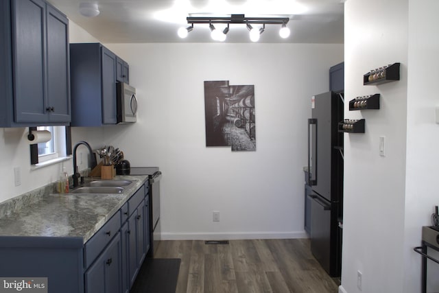 kitchen with sink, dark hardwood / wood-style floors, stainless steel appliances, and blue cabinets