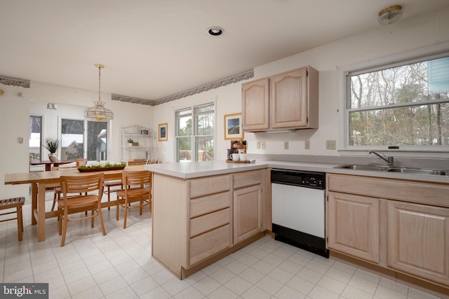 kitchen with dishwasher, decorative light fixtures, light brown cabinetry, sink, and kitchen peninsula