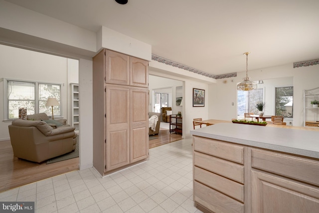 kitchen featuring decorative light fixtures, a wealth of natural light, and light brown cabinets