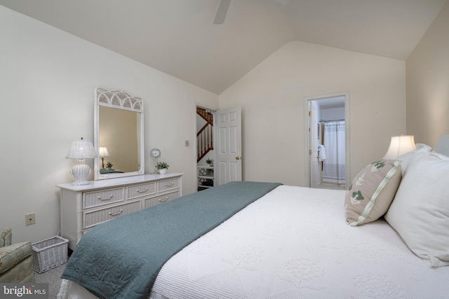 bedroom with ceiling fan, lofted ceiling, and ensuite bath