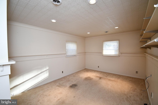 spare room with ornamental molding and light colored carpet