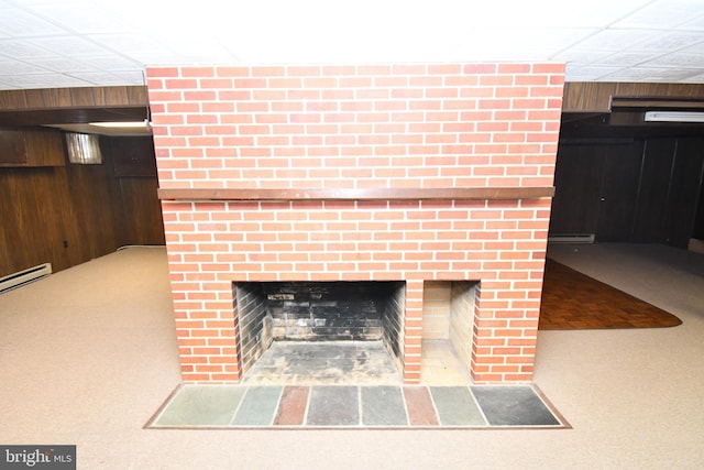 room details featuring a brick fireplace, a paneled ceiling, carpet, and wood walls