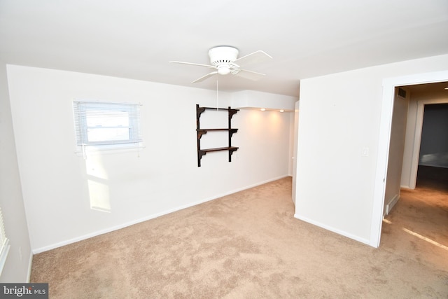 carpeted spare room featuring ceiling fan