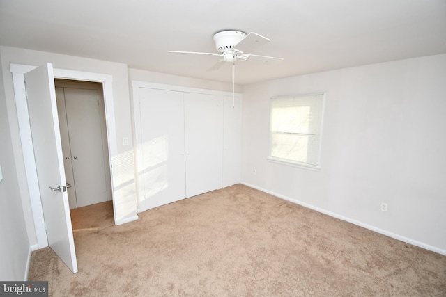 unfurnished bedroom with light carpet, ceiling fan, and a closet