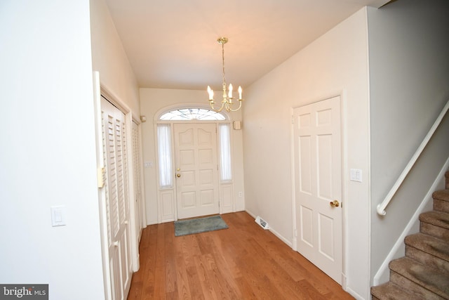 foyer entrance featuring hardwood / wood-style floors and an inviting chandelier