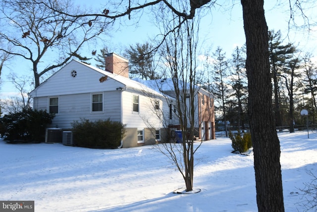 snow covered property with central air condition unit