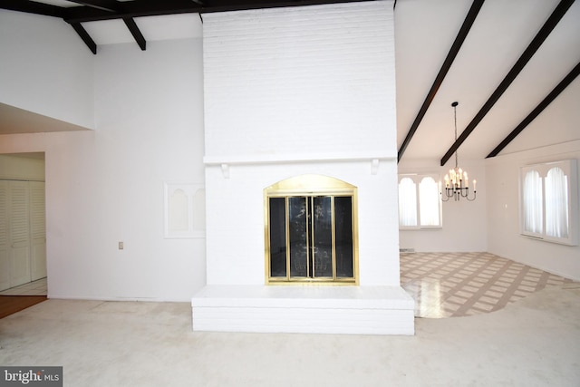 unfurnished living room with lofted ceiling with beams, a chandelier, and carpet flooring