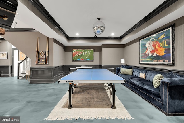 game room with concrete floors, a tray ceiling, and crown molding