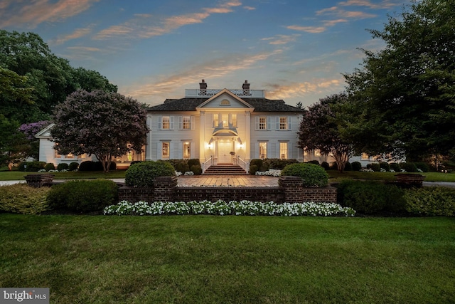 neoclassical home featuring a lawn