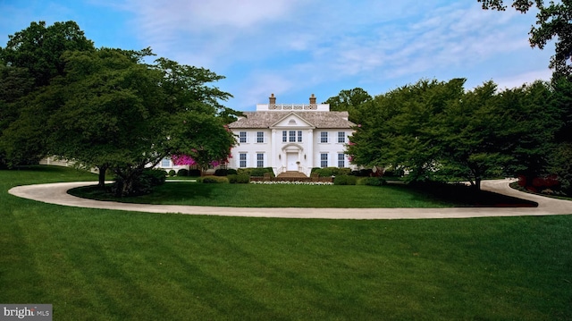 colonial-style house with a front lawn