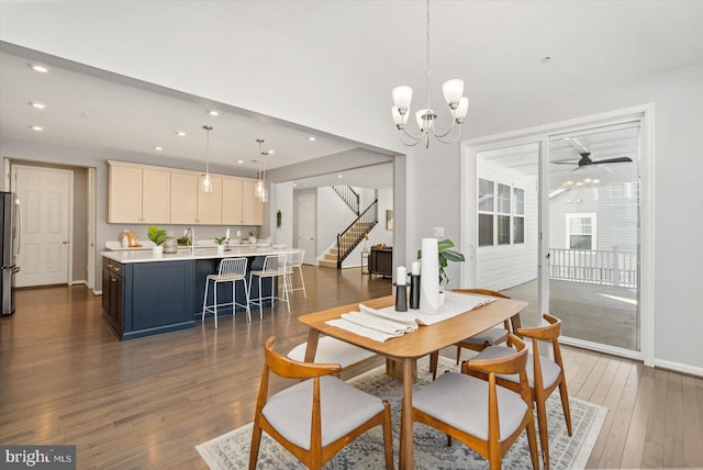 dining area featuring sink, ceiling fan with notable chandelier, and dark hardwood / wood-style floors