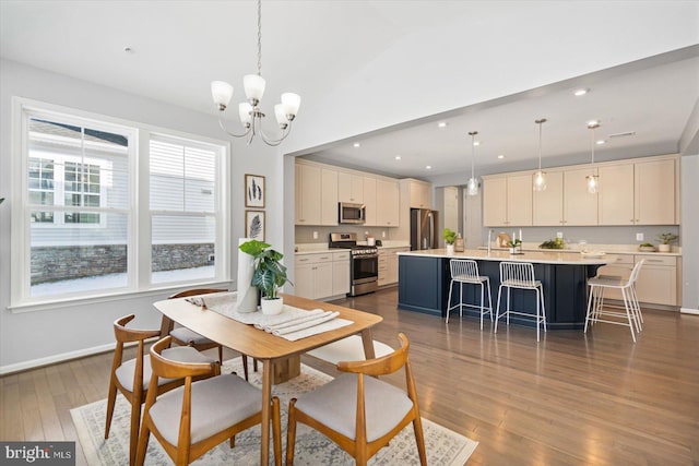 dining room featuring hardwood / wood-style flooring, an inviting chandelier, vaulted ceiling, and a wealth of natural light