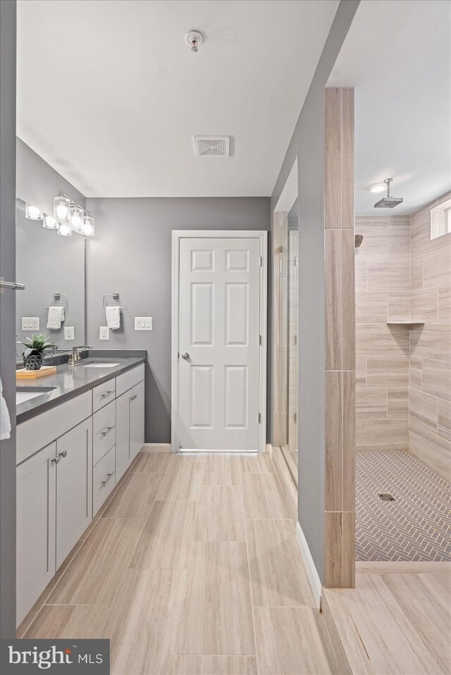 bathroom with vanity and a tile shower