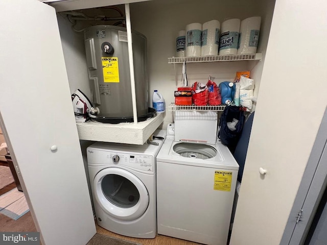 washroom with independent washer and dryer, hardwood / wood-style flooring, and water heater