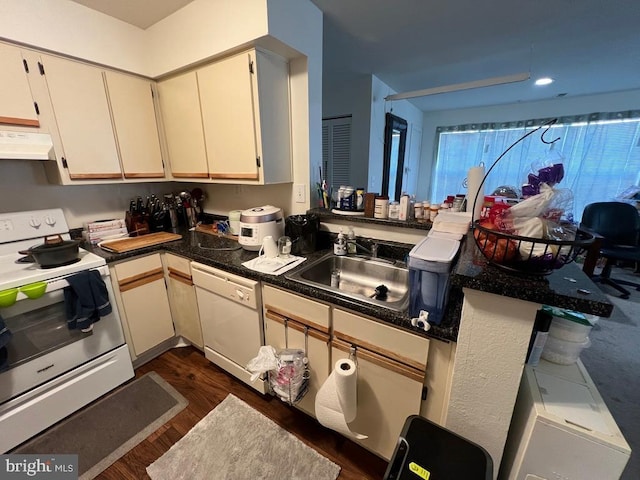 kitchen featuring sink, kitchen peninsula, dark wood-type flooring, white appliances, and cream cabinetry