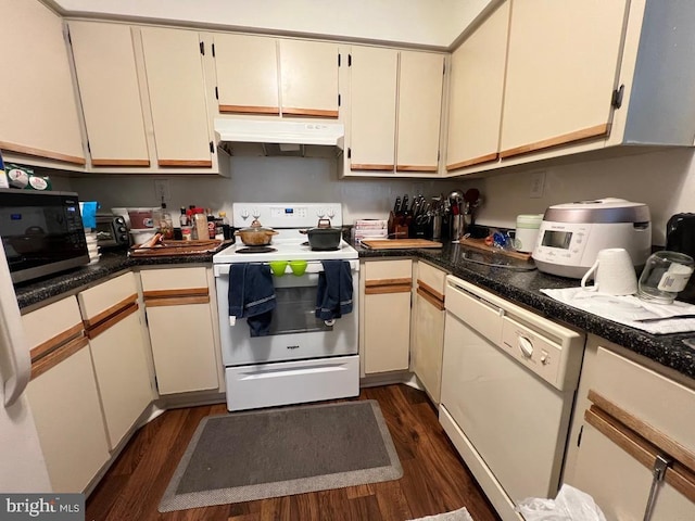 kitchen featuring dark wood-type flooring, white appliances, and cream cabinetry