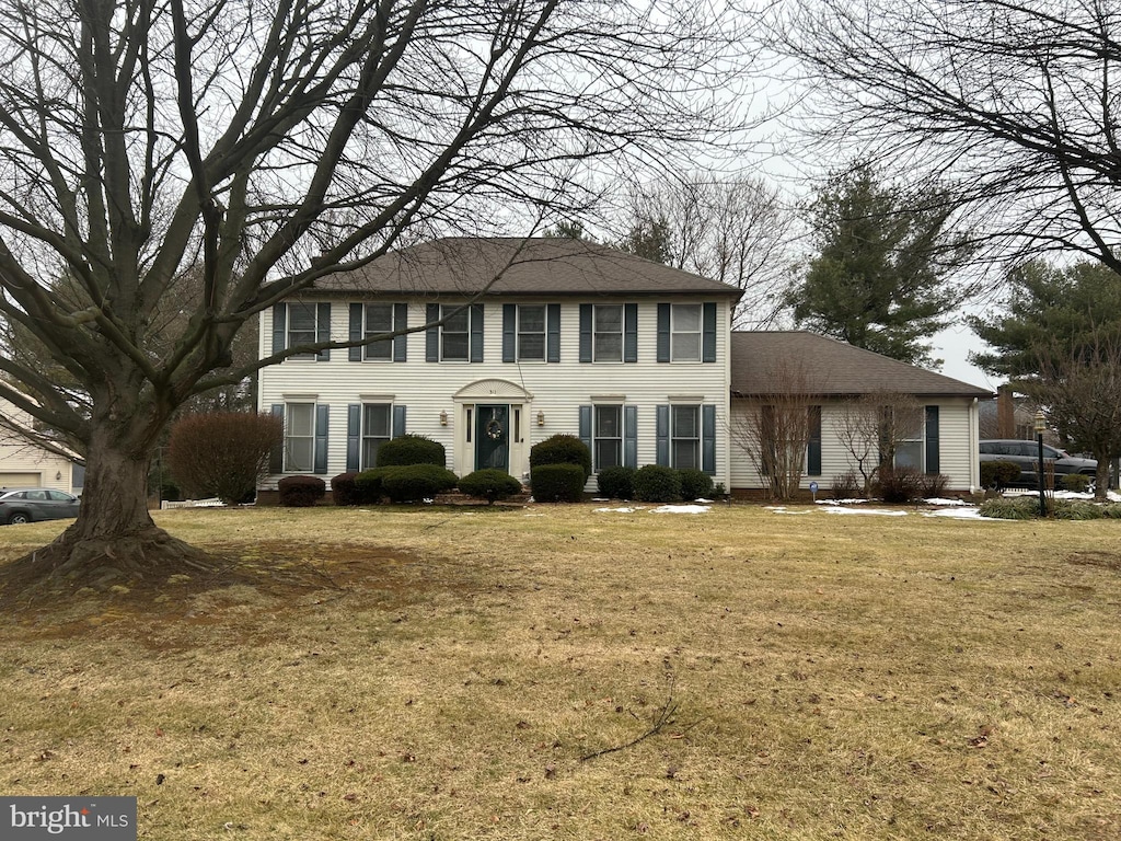 colonial inspired home with a front lawn