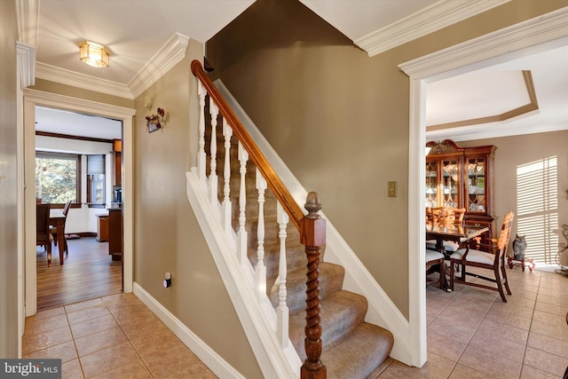 stairs featuring tile patterned flooring and crown molding