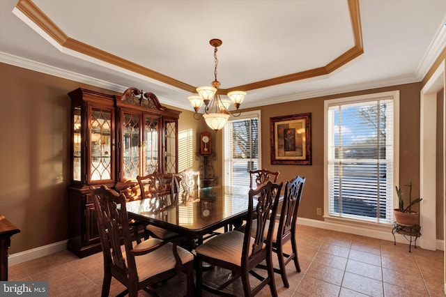 dining area with a raised ceiling and crown molding