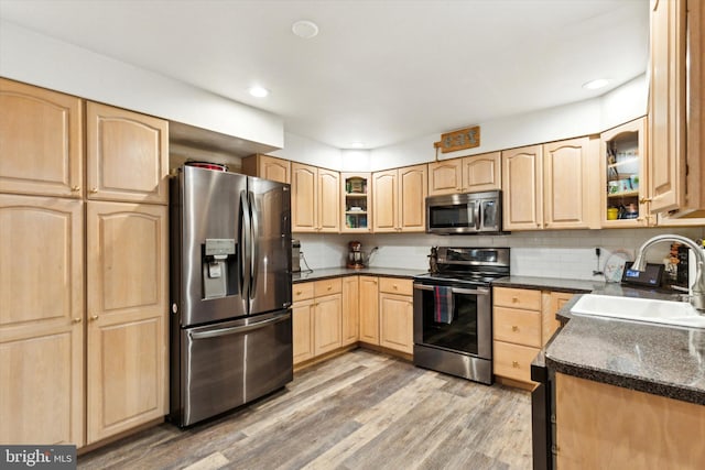 kitchen featuring light brown cabinetry, backsplash, sink, and stainless steel appliances