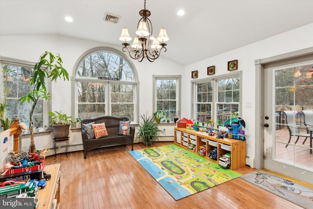 sunroom / solarium with a baseboard heating unit, lofted ceiling, and a notable chandelier