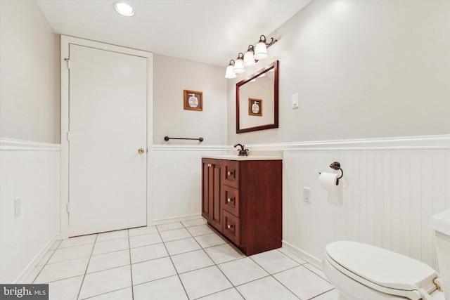 bathroom with toilet, vanity, and tile patterned flooring