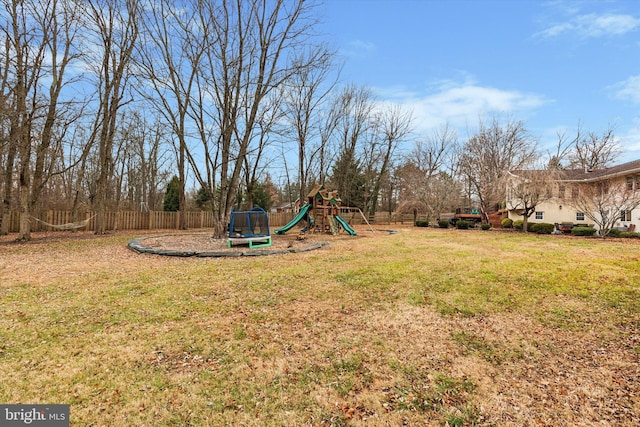 view of yard with a playground and a trampoline