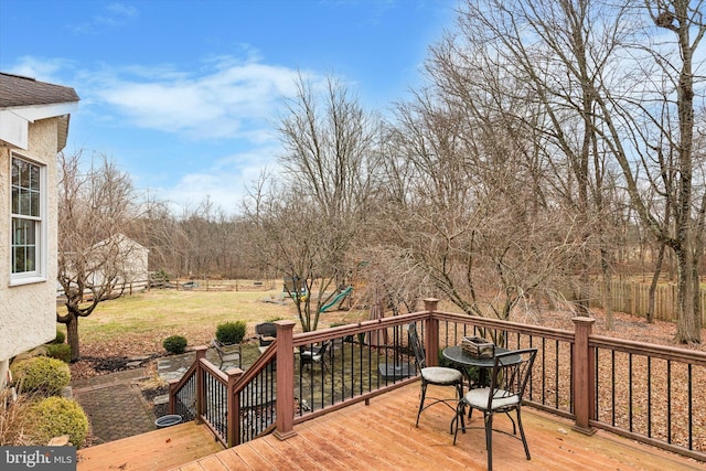 deck featuring a playground and a yard