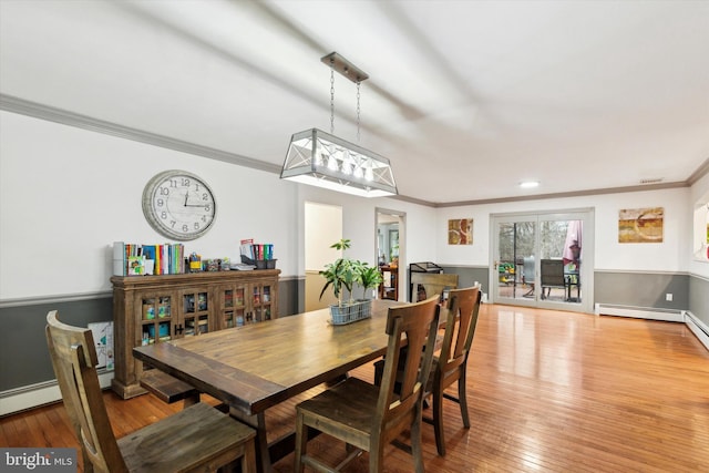 dining space featuring ornamental molding and light wood-type flooring