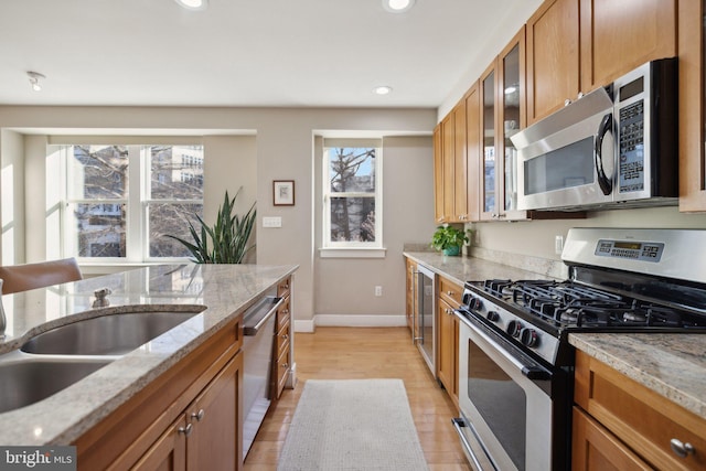 kitchen featuring light stone countertops, a healthy amount of sunlight, and appliances with stainless steel finishes