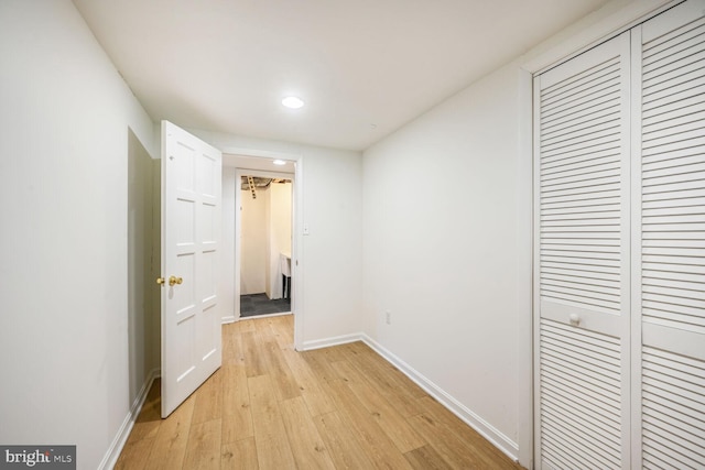 hallway with light wood-style flooring and baseboards