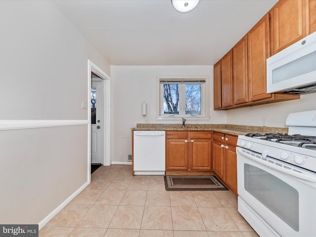 kitchen with white appliances, sink, and light tile patterned floors