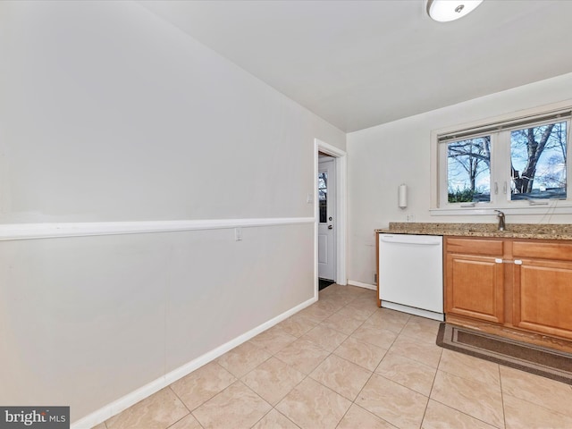 kitchen featuring dishwasher, sink, light tile patterned floors, and light stone counters