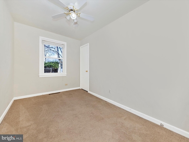 carpeted spare room with ceiling fan