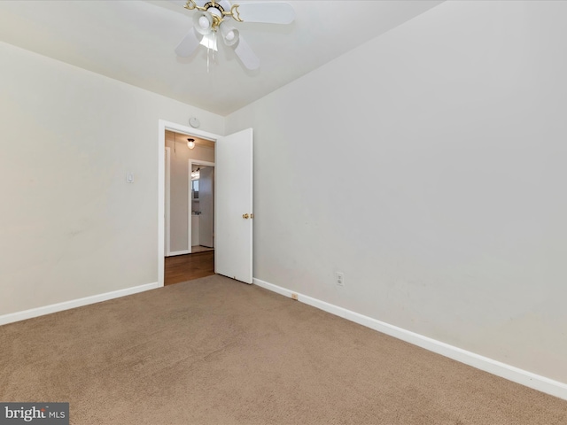 empty room featuring ceiling fan and carpet