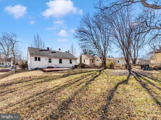 rear view of house with a wooden deck and a yard