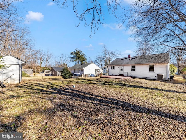 back of house with central AC unit, a yard, a patio area, and a storage unit