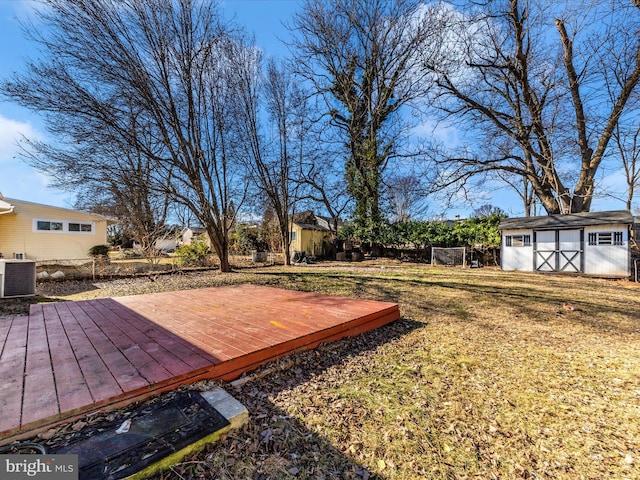 view of yard featuring central AC, a deck, and a shed