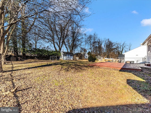 view of yard featuring a wooden deck and a storage unit