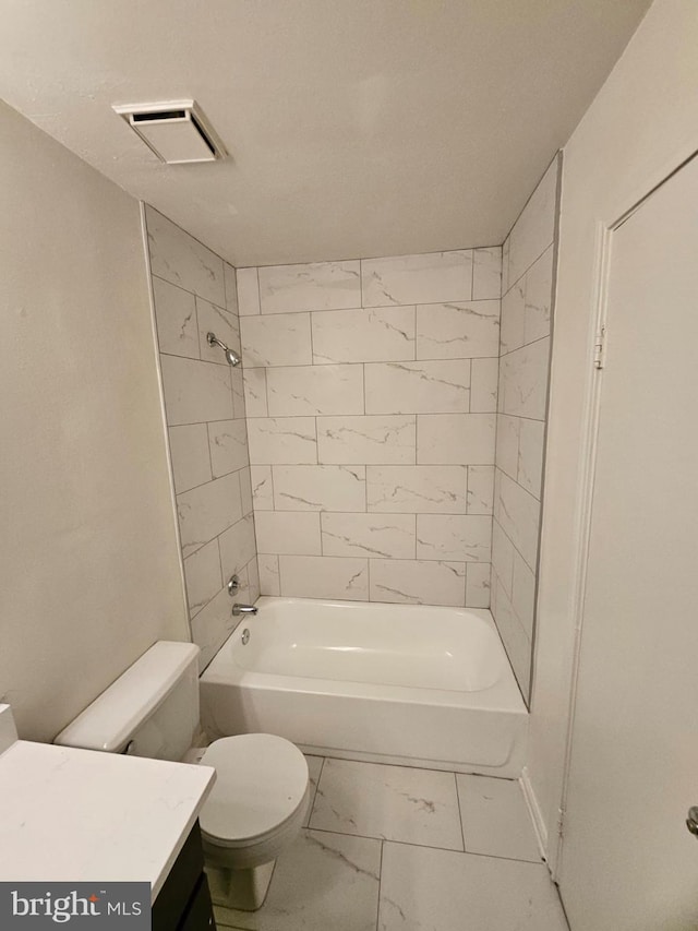 full bathroom with tiled shower / bath, vanity, and toilet