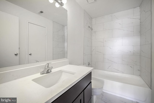 full bathroom with vanity, tiled shower / bath combo, and toilet