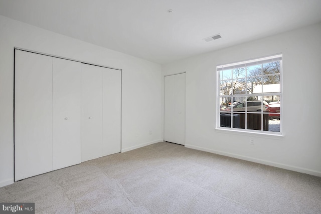 unfurnished bedroom with a closet and light carpet