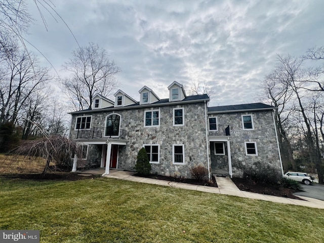 view of front of house featuring stone siding and a front lawn