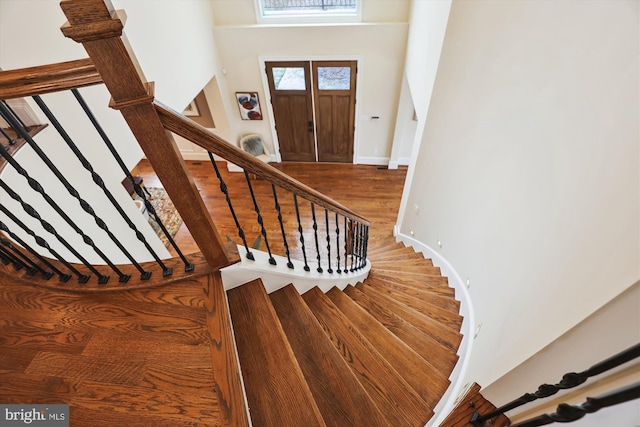 stairs featuring wood finished floors and baseboards