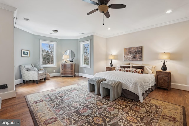 bedroom with baseboards, visible vents, wood finished floors, and ornamental molding