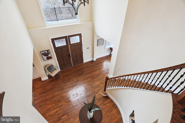 foyer with dark wood-style flooring, baseboards, a high ceiling, and stairs