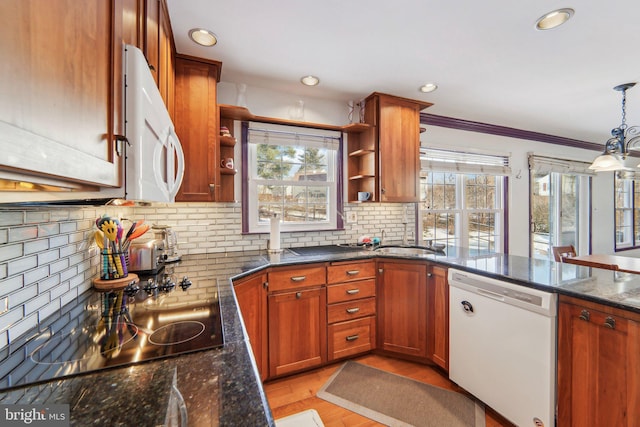 kitchen with white appliances, dark stone countertops, hanging light fixtures, tasteful backsplash, and ornamental molding